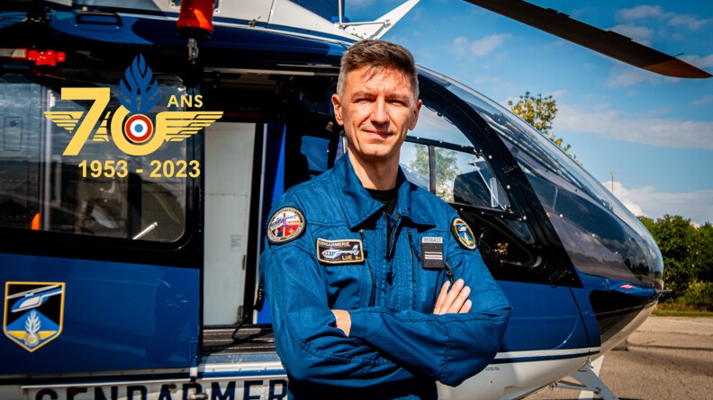 Pilote des Forces aérienne de la gendarmerie nationale devant un hélicoptère de la gendarmerie.
