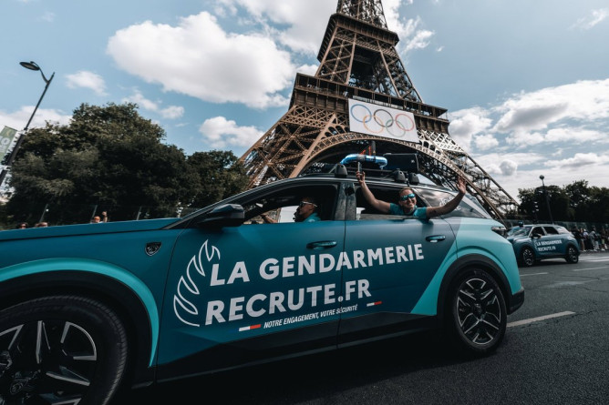 Agrandir l'image Une voitire de la gendarmerie passe devant la Tour Eiffel. Sur la portière est écrit "La gendaremerie recrute.fr"