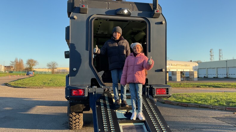 Agrandir l'image Les enfants descendant du véhicule blindé.