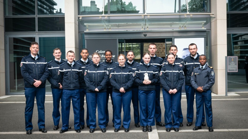 Sur la place d'arme de la direction g&eacute;n&eacute;rale de la gendarmerie nationale, les quinze &eacute;l&egrave;ves de la Classe Pr&eacute;pa-Talents de Paris, posent ensemble, devant les portes d'entr&eacute;e du batiment.