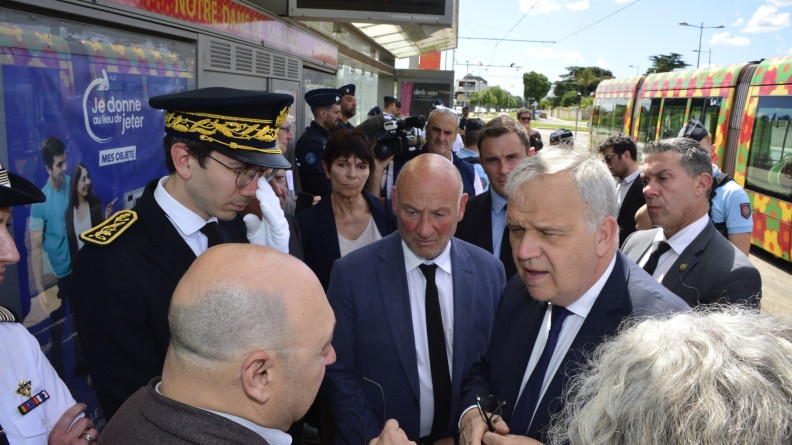 Plusieurs personnes sont mass&eacute;es sur le quai du tramway. Photo prise de jour, par un temps ensoleill&eacute;.
