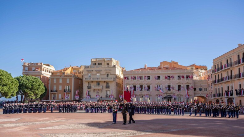 en arrière plan les miltalires de la garde républicaine et de la garde de monaco, au centre des militaires saluant vers le haut