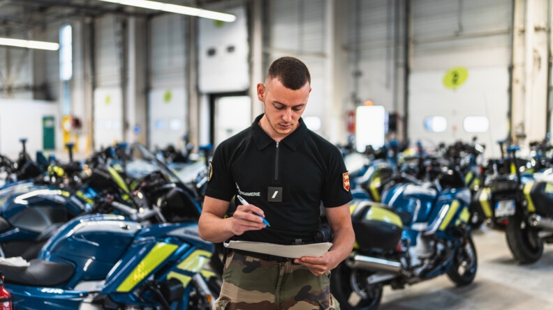 Maintenance des motos par un gendarme à la Base logistique avancée du 80e anniversaire du débarquement.