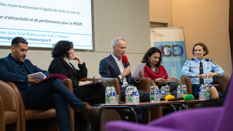 Devant un &eacute;cran lumineux, cinq intervenants &eacute;changent &agrave; l'occasion du s&eacute;minaire.