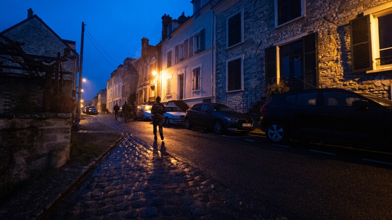 Un groupe de miliciens progressent de nuit dans un village