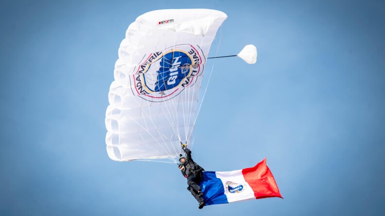 Agrandir l'image Une parachutiste en plein vol avec un grand drapeau français accroché à sa jambe