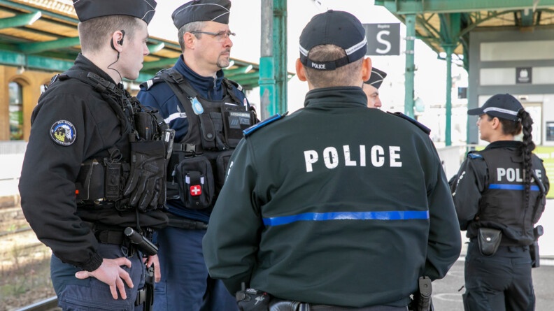 De dos un policier luembourgeois avec deux gendarmes fran&ccedil;ais sur le quai d'une gare.