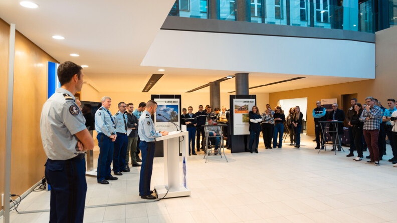 Des gendarmes en train de pr&eacute;senter l'exposition devant plusieurs personnes.