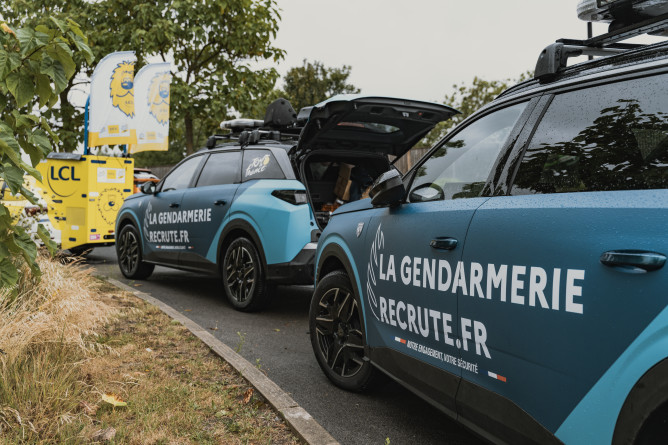 Agrandir l'image Véhicules de la caravane gendarmerie stationnés sur le parking avant le début de la course.