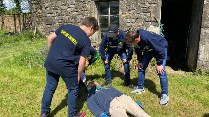 Quatre jeunes cadets observent le corps de la victime représenter par un mannequin, pour déterminer les causes de la mort et trouver des indices.