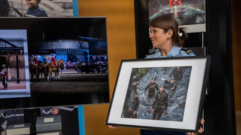 La gendarme tient dans ses mains la photo de Florian Garcia qui a &eacute;t&eacute; choisi par J&eacute;r&ocirc;me Pitorin. La photo repr&eacute;sente une femme en treilli qui d&eacute;couvre un obstacle dans un parcour du combattant. Sa bouche est grande ouverte et elle est surprise. Autour d'elle, ses camarades en treilli sont aussi dans l'eau.