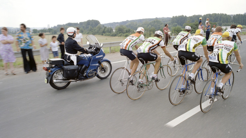 Photo d'archive montrant un militaire de la gendarmerie à moto derrière un peloton de cyclistes sur un route bordée