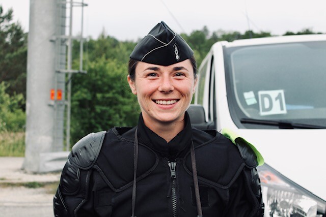 Agrandir l'image Portrait en buste d'une gendarme en noir avec des protections de maintien de l'ordre