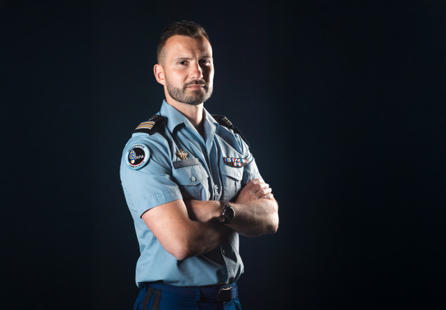 Portrait en buste du lieutenant-colonel Erwan Coiffard, en chemisette bleue gendarmerie, les bras croisés, vu de trois-quarts face.