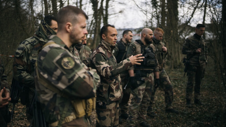 Une dizaine de gendarmes et militaires en treillis dans la forêt