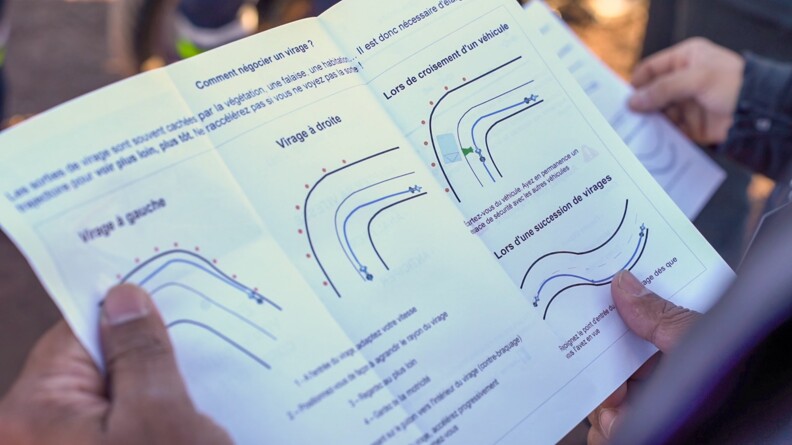 Vue en gros plan d'un papier sur lequel se trouve des conseils pour réaliser de bonnes trajectoires en deux roues.