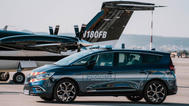 Agrandir l'image Une voiture bleue marine, portant sur la portière l'inscription "Gendarmerie - Notre engagement, votre sécurité", est garée sur la piste d'un aéroport, devant un petit avion d'affaires de couleur noire et blanche