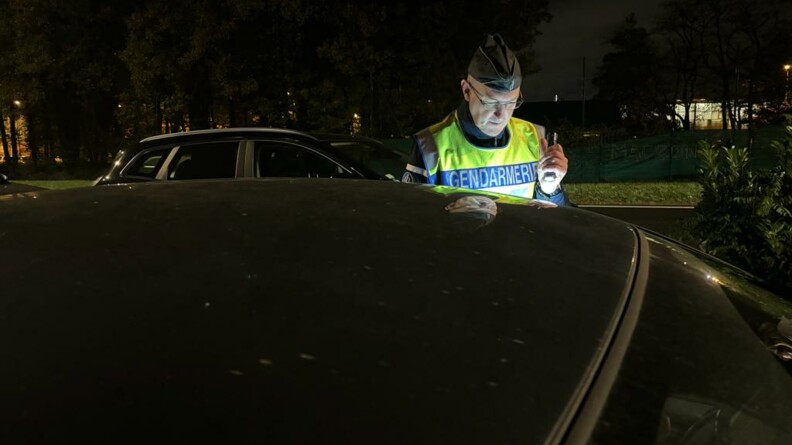 Un gendarme contr&ocirc;le un v&eacute;hicule de nuit.