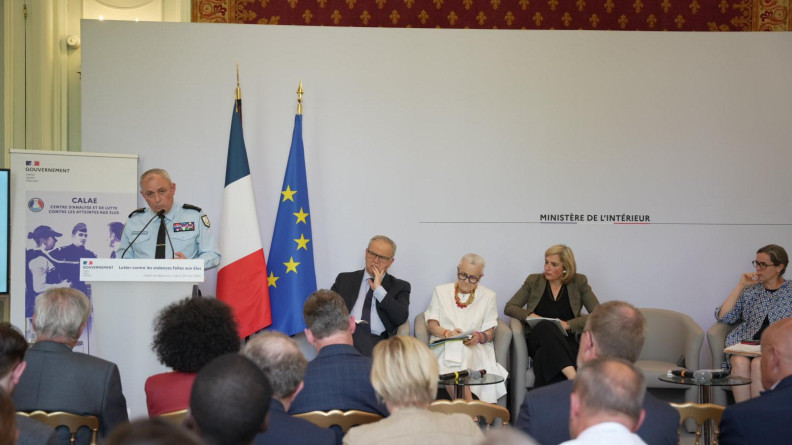 Agrandir l'image vue large du DGGN en train de parler devant une assemblée. A côté de lui se trouve des ministres, derrière lui se trouve le drapeau de la France et celui de l'europe et un fond sur lequel est inscrit "Ministère de l'Intérieur."