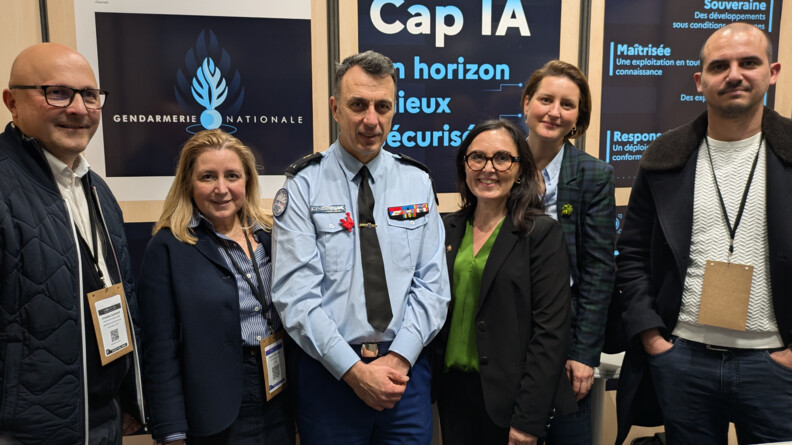 Agrandir l'image Un général de gendarmerie entouré de trois femmes et deux hommes devant des kakémonos évoquant la gendarmerie nationale et l'intelligence artificielle