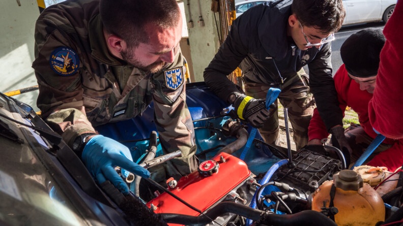 Agrandir l'image Trois gendarmes en treillis ou sweat dont un portant la rondache de l'association 4l bleues tirent sur des cables pour soritr le morteur d'unel