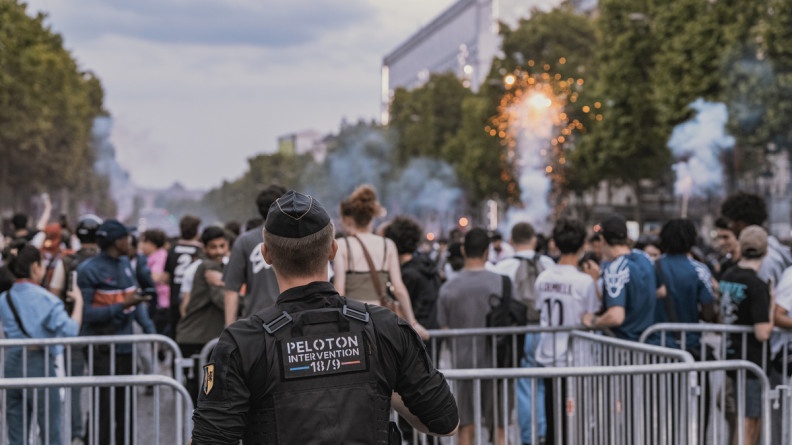 Photo d'un gendarme, de dos, lors des festivités à l'occasion de la victoire du PSG lors de la Ligue des Champions 2025