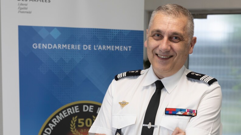 Le colonel Urien, pose devant un kakemono de la gendarmerie de l'armement.