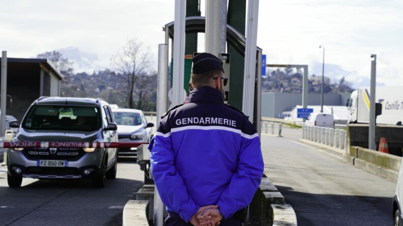 Un gendarme de dos devant un péage