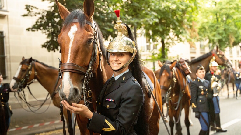 Une garde républicaine avec son cheval, sourie face à la caméra
