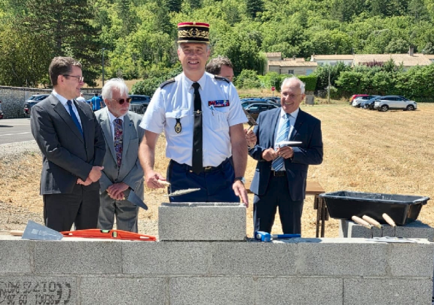 Agrandir l'image La photo représente un général de gendarmerie, commandant de la région PACA, posant unepierre sur un muret