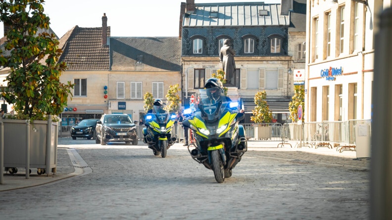 Des les rues du centre ville de Villers-Cotter&ecirc;ts, deux gendarmes motocyclistes pr&eacute;c&egrave;dent deux voitures de couleur sombre