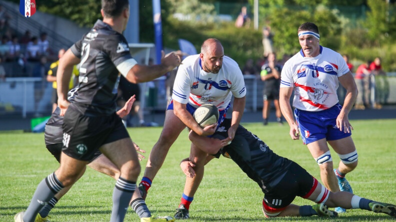 Agrandir l'image Un équipier de l'armée de terre plaque un rugbyman du XV gendarmerie. A droite, deux coéquipiers armée de terre et à gauche un de la gendarmerie fondent sur l'action