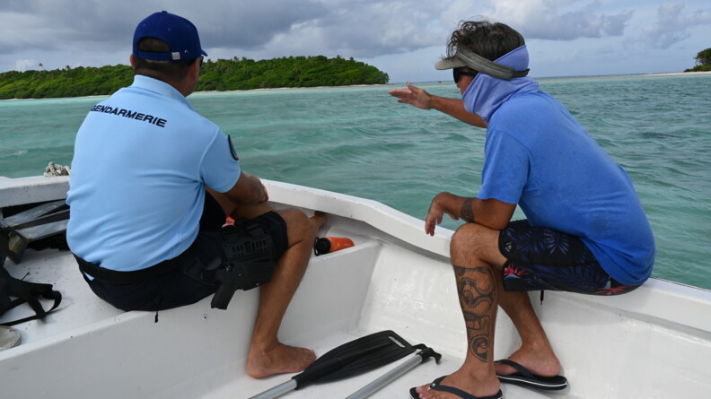Un gendarme et un civil sur un bateau en mer.