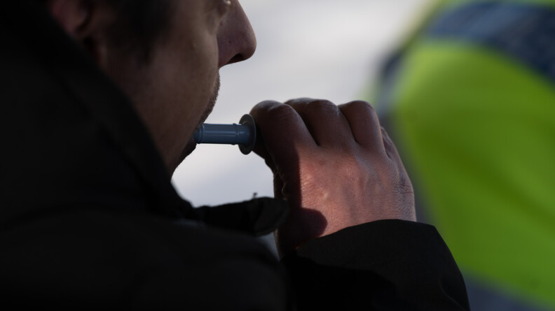 Agrandir l'image Un conducteur de bus en gros plan en train de réaliser un test d'alcoolémie.