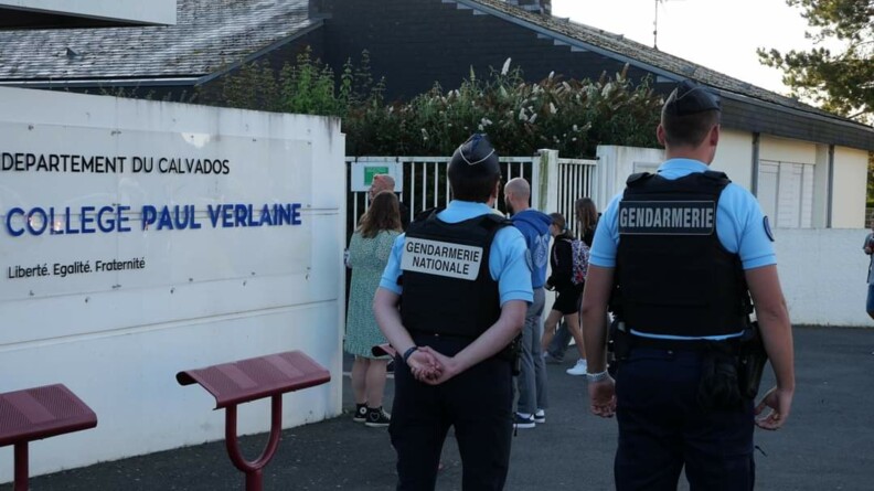 Agrandir l'image Deux gendarmes devant l'entrée d'un collège.