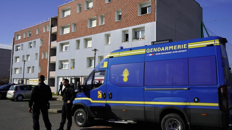 Agrandir l'image Deux gendarmes mobiles devant un véhicule de maintien de l'ordre au pied d'un immeuble
