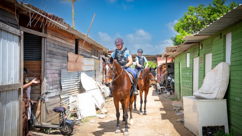 Groupe équestre patrouillant dans un quartier informel de Kourou.