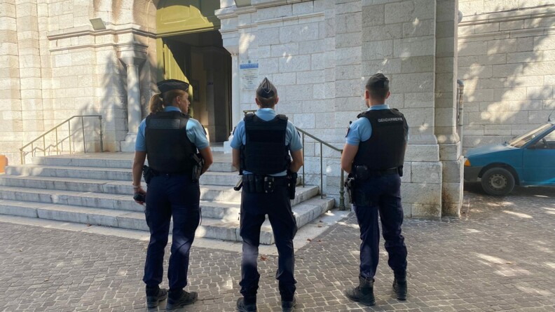 Agrandir l'image Trois gendarmes devant une église, veillent à ce que personnes ne viennent troubler la cérémonie de l'Assomption.