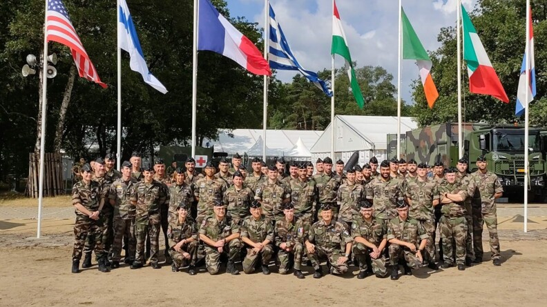 Agrandir l'image Le détachement de la gendarmerie nationale pose devant les drapeaux des pays participants.