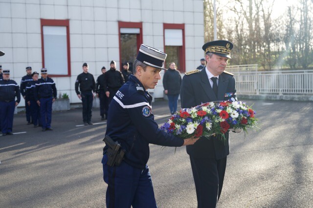 Une autorité civile et une autorité militaire déposent une gerbe de fleurs.