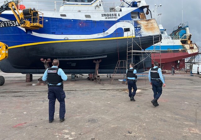 Trois gendarmes &eacute;voluent autour d'un bateau bleu et blanc, enti&egrave;rement sorti de l'eau, portant sur la coque l'inscription "Iroise 1"