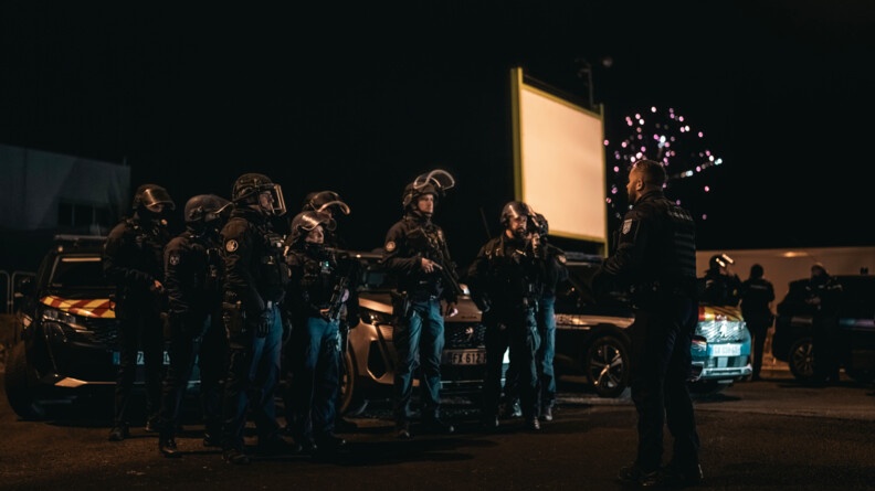 Des gendarmes en tenue d'intervention en train d'écouter le briefing de leur commandant.
