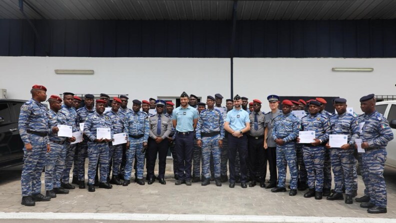 Photo de groupe d'une trentaine d'officiers de la gendarmerie ivoirienne en treillis bleus et gris, tenant des dîplômes, avec au centre de la photo deux officiers du Centre national des opérations français.