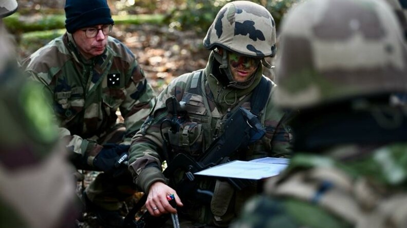Le GCA ainsi qu'un autre gendarme sont accroupis dans la for&ecirc;t.