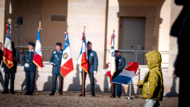 Photo d'anciens combattants, se debout, avec un drapeau dans leur main gauche, lors de la prise d'arme du 7 janvier 2025 dans la cour de l'h&ocirc;tel national des Invalides, &agrave; Paris