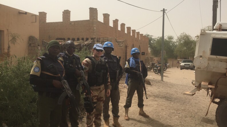 Un gendarme entouré de quatre membres de la patrouille, armés, dans les rues de Tombouctou.