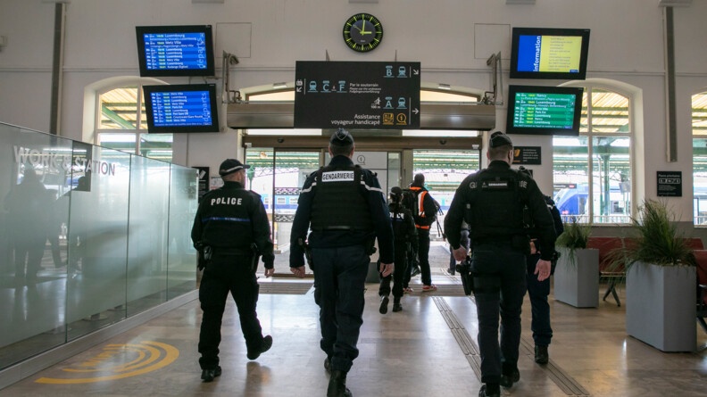 Trois gendarmes et deux policiers luxembourgeois de dos s'apprêtent à sortir d'une gare
