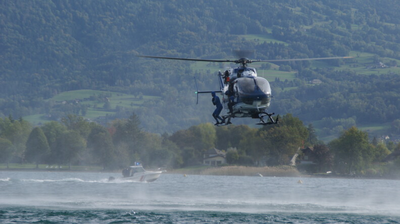 Au dessus du lac, un gendarme plongeur se prépare à sauter dans l'eau.