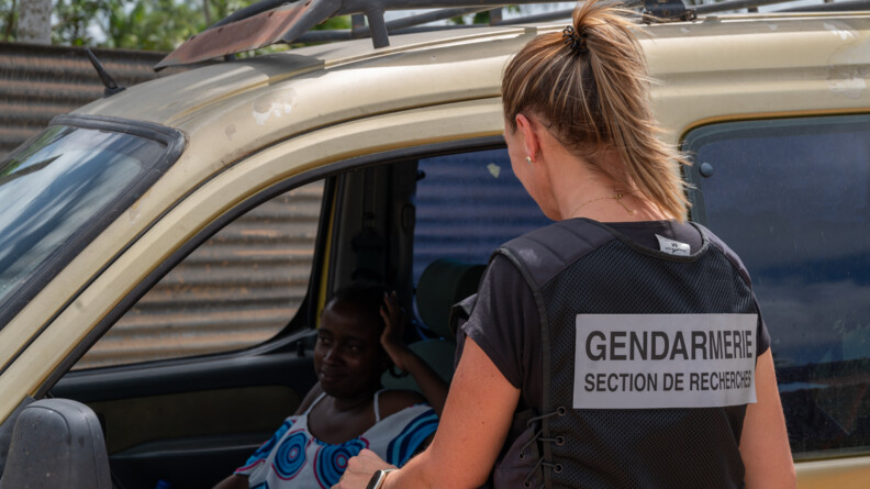 Gendarme de la S.R. &eacute;changeant avec une habitante.
