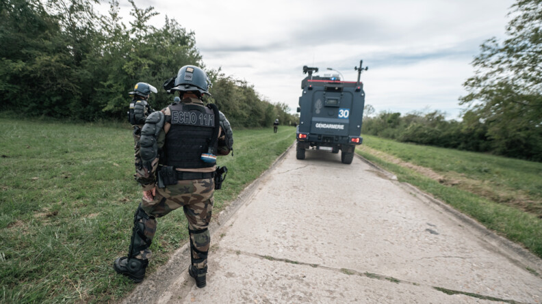 Agrandir l'image Un gendarme mobile avec un patch Echo 11/1 au premier plan. Au second plan un Centaure numéroté 30.